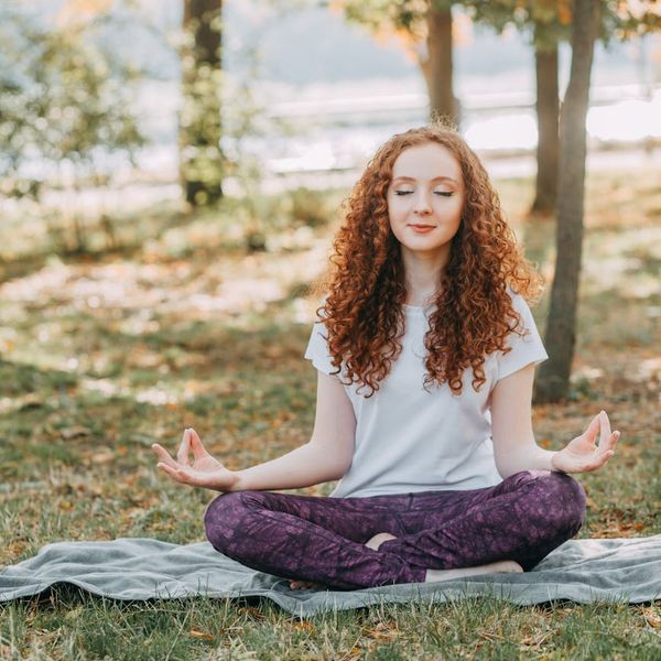 Person meditating in a calm natural environment, symbolizing inner peace.